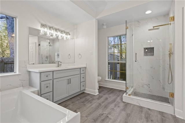 full bathroom with vanity, toilet, separate shower and tub, and hardwood / wood-style floors