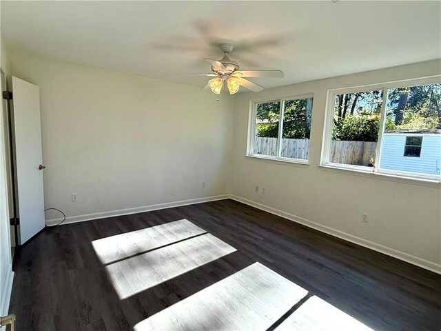 unfurnished room with ceiling fan and dark wood-type flooring