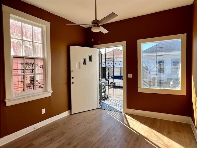 doorway with ceiling fan and hardwood / wood-style floors