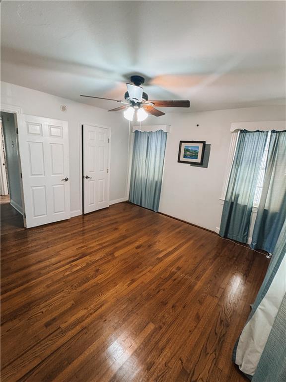 interior space featuring dark wood-type flooring and ceiling fan