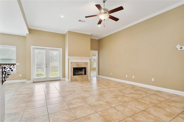 unfurnished living room with light tile patterned flooring, ceiling fan, ornamental molding, and a fireplace