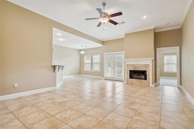 unfurnished living room featuring light tile patterned floors, ceiling fan, ornamental molding, and a tile fireplace