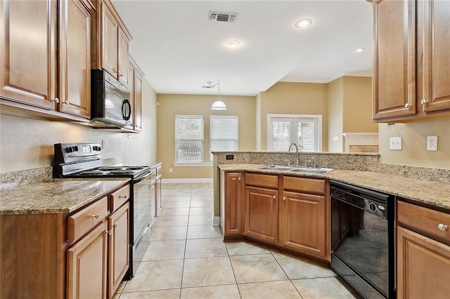 kitchen featuring decorative light fixtures, light tile patterned flooring, black appliances, light stone counters, and sink