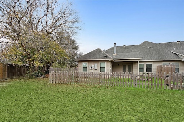 rear view of property with a lawn