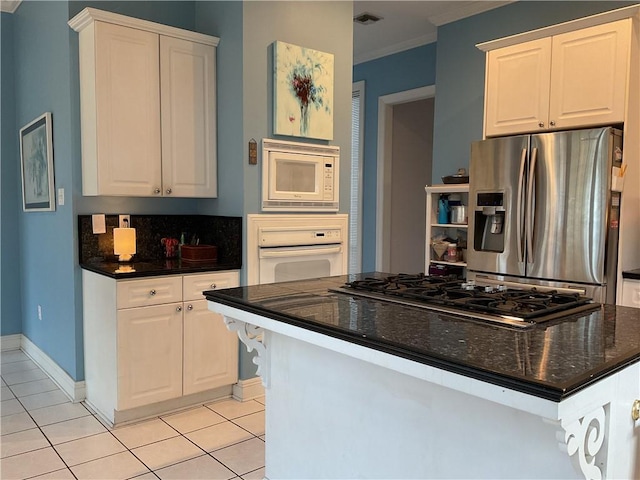 kitchen with light tile patterned floors, crown molding, white cabinets, and white appliances