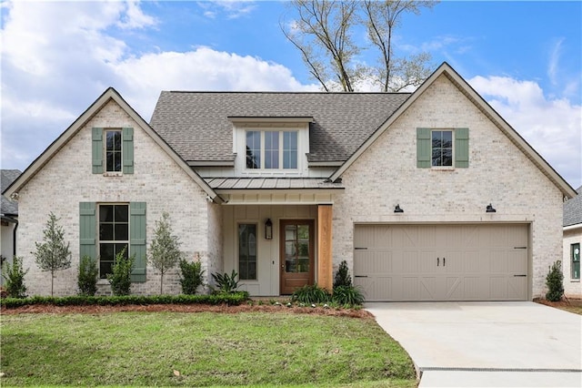 5044 Twin River Pl, Covington, LA 70433 - view of front facade featuring brick siding, roof with shingles, a standing seam roof, a garage, and concrete driveway