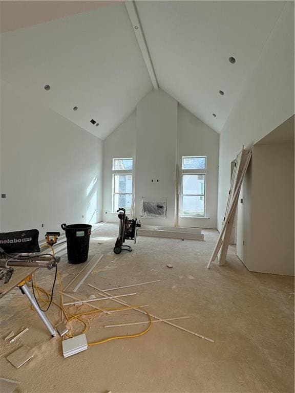 unfurnished living room with high vaulted ceiling