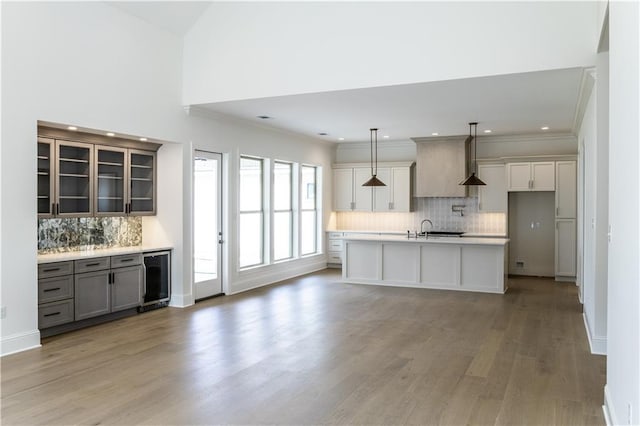 5044 Twin River Pl, Covington, LA 70433 - kitchen featuring decorative backsplash, light wood-type flooring, light countertops, wine cooler, and a sink