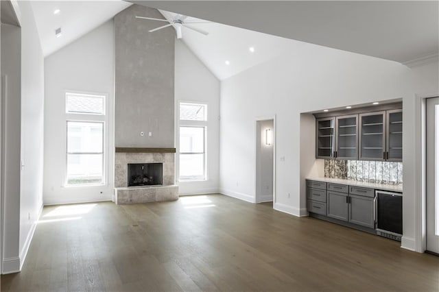 5044 Twin River Pl, Covington, LA 70433 - unfurnished living room with high vaulted ceiling, a ceiling fan, wine cooler, dark wood-style floors, and a fireplace