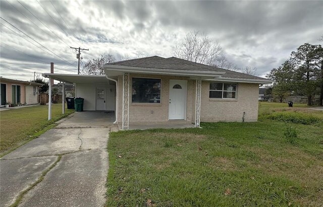 view of front of property with a front lawn and a carport