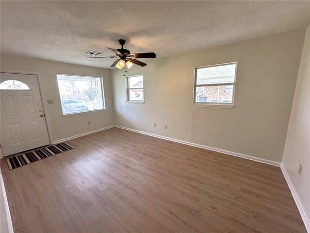 foyer entrance featuring a textured ceiling, ceiling fan, and wood-type flooring