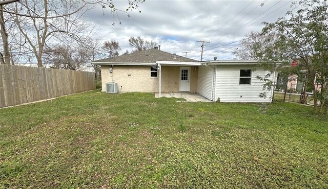 rear view of house with a yard and central air condition unit