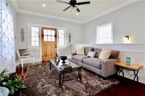 living room with ceiling fan, wood-type flooring, and crown molding