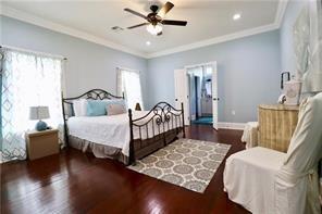 bedroom with ceiling fan, multiple windows, dark hardwood / wood-style floors, and crown molding