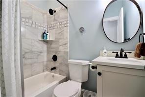 full bathroom with toilet, shower / bathtub combination with curtain, and vanity