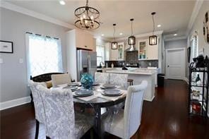 dining room featuring dark hardwood / wood-style flooring, ornamental molding, and a notable chandelier