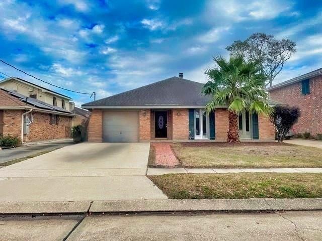 ranch-style home featuring a garage, concrete driveway, brick siding, and a front lawn