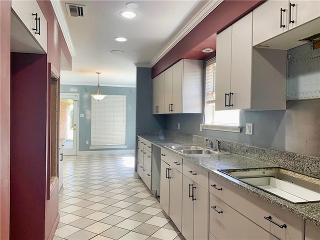 kitchen with light tile patterned floors, hanging light fixtures, ornamental molding, white cabinetry, and a sink