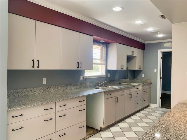 kitchen with black electric cooktop, recessed lighting, a sink, white cabinets, and ornamental molding