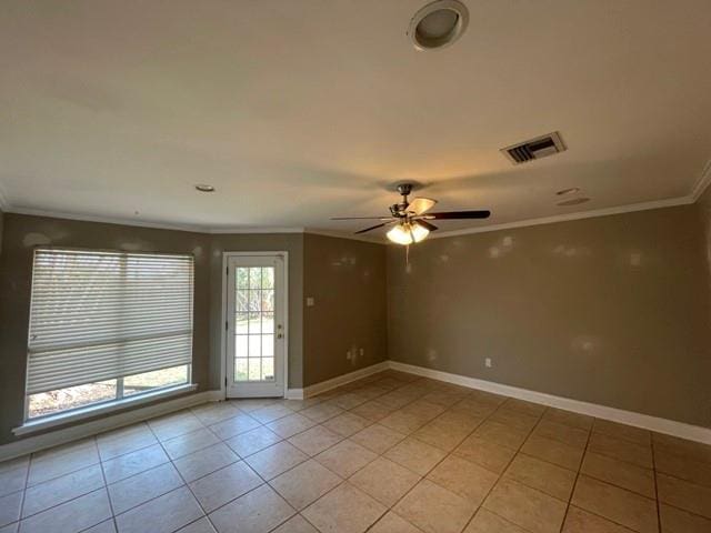 empty room with light tile patterned floors, ceiling fan, and ornamental molding