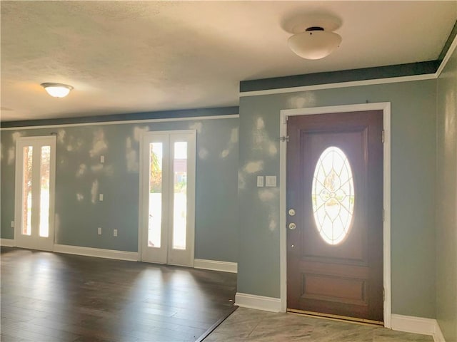 foyer featuring baseboards, wood finished floors, and french doors