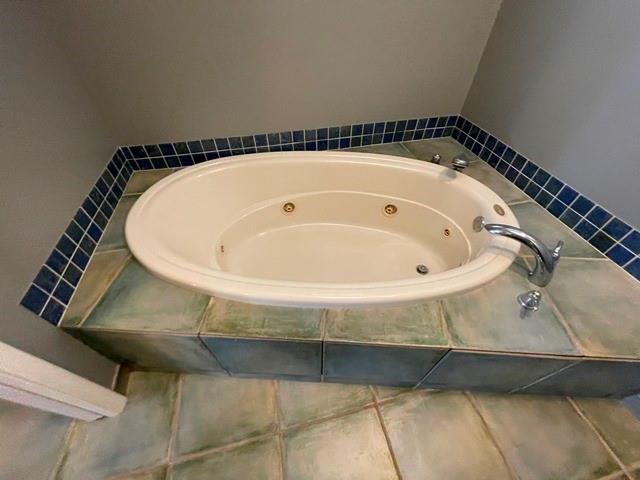 bathroom featuring tiled bath and tile patterned floors