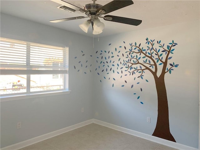 spare room featuring light tile patterned flooring, ceiling fan, and baseboards