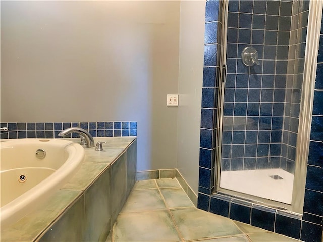 full bath with a whirlpool tub, baseboards, tile patterned flooring, and a shower stall