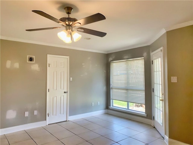 spare room with light tile patterned floors, baseboards, and crown molding