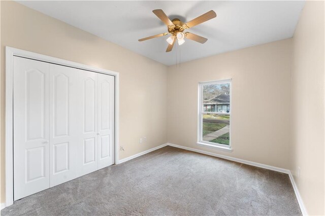 unfurnished bedroom with ceiling fan, a closet, and carpet floors