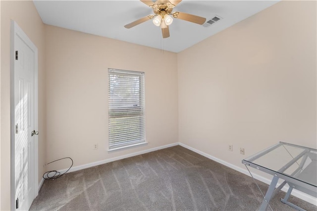 empty room featuring ceiling fan and dark colored carpet