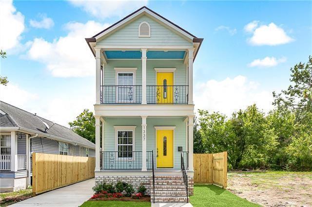 shotgun-style home with a porch, fence, and a balcony