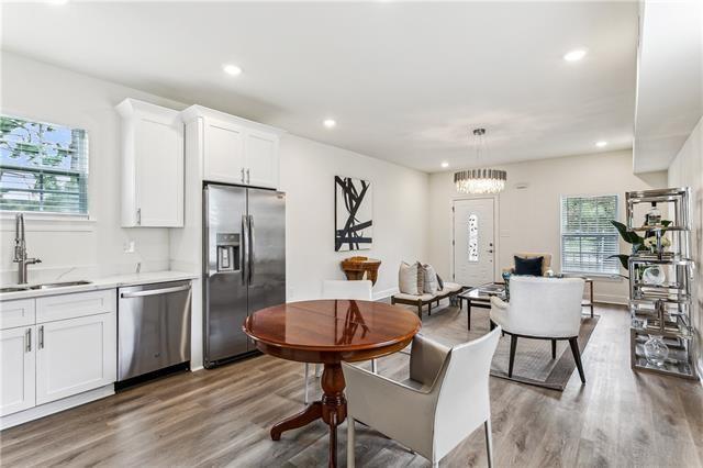 kitchen with light wood finished floors, appliances with stainless steel finishes, white cabinetry, a sink, and recessed lighting