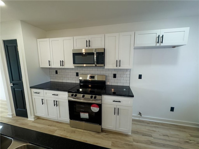 kitchen featuring white cabinetry, appliances with stainless steel finishes, and backsplash