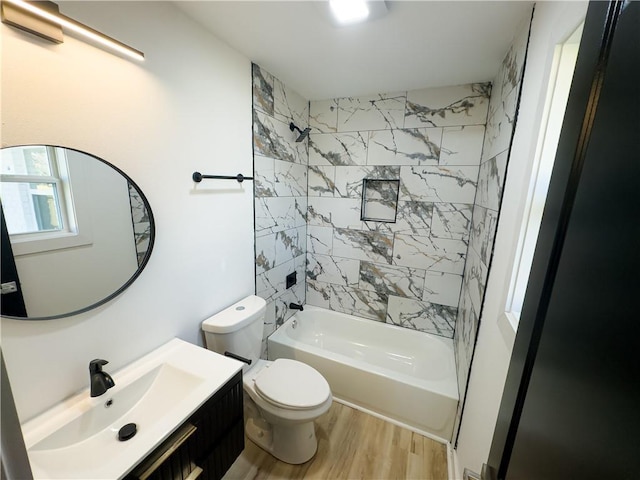 full bathroom featuring tiled shower / bath, vanity, toilet, and hardwood / wood-style floors