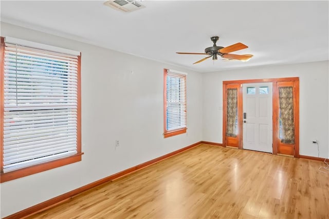 foyer entrance with ceiling fan, a healthy amount of sunlight, and light hardwood / wood-style floors