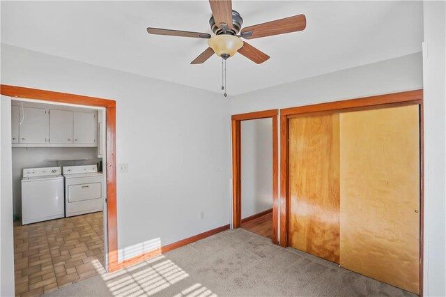 unfurnished bedroom featuring separate washer and dryer, light colored carpet, and ceiling fan