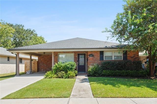 single story home featuring a front yard and a carport