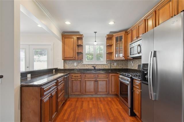 kitchen featuring crown molding, pendant lighting, a wealth of natural light, and stainless steel appliances