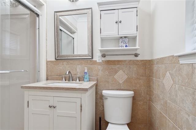 bathroom featuring toilet, an enclosed shower, and vanity