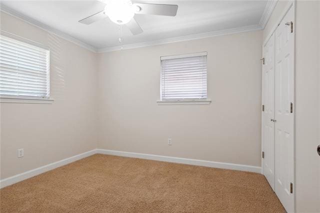 unfurnished bedroom with crown molding, carpet, and ceiling fan