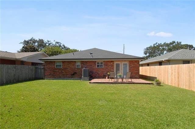 rear view of house with a patio area, a lawn, and cooling unit