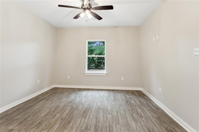 empty room with ceiling fan and dark hardwood / wood-style flooring