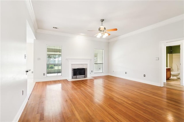 unfurnished living room with ceiling fan, crown molding, a fireplace, and light hardwood / wood-style flooring