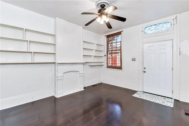 foyer entrance with ceiling fan and dark wood-type flooring