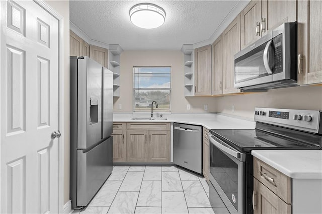 kitchen featuring sink, a textured ceiling, appliances with stainless steel finishes, and light brown cabinets