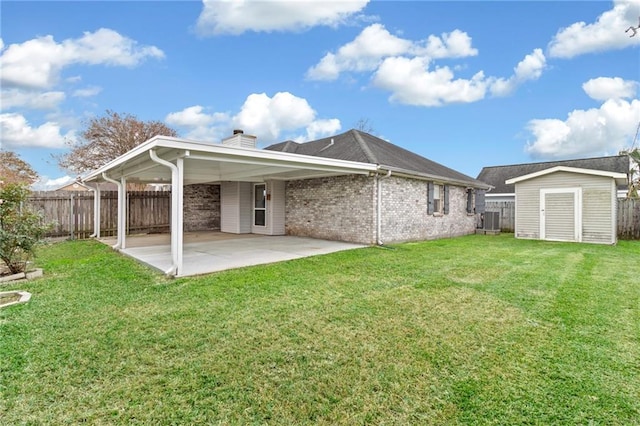 back of house featuring central AC unit, a yard, a patio area, and a storage unit