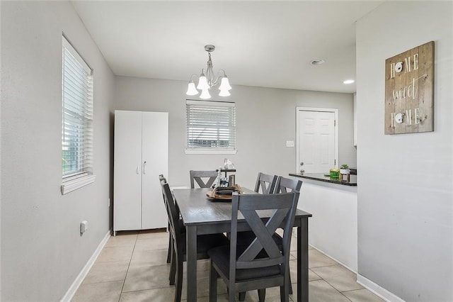 tiled dining room featuring an inviting chandelier