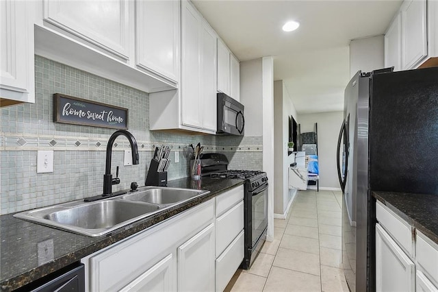 kitchen with light tile patterned floors, white cabinetry, backsplash, dark stone countertops, and black appliances