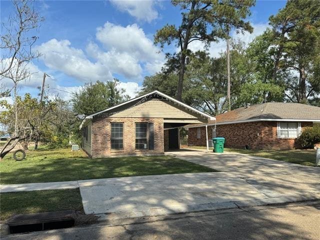 single story home featuring a carport and a front yard